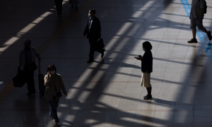 Một người đi bộ sử dụng điện thoại thông minh tại ga Seoul, Hàn Quốc. Ảnh: Bloomberg