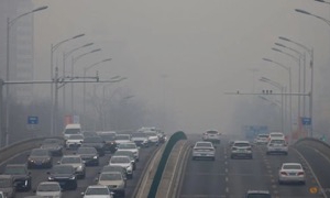 Ô tô di chuyển trên đường trong không khí ô nhiễm tại Bắc Kinh. Ảnh: Reuters