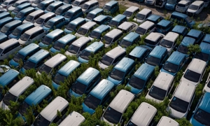 Nằm trong cỏ dại và rác rưởi, hàng trăm chiếc xe điện bị vứt bỏ. Ảnh: Qilai Shen/Bloomberg