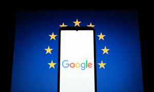 Biểu trưng Google hiển thị trên màn hình điện thoại thông minh và cờ châu Âu trên màn hình máy tính.
