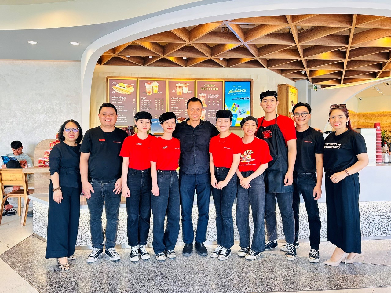 Ông Thái Anh cùng các nhân viên của Highlands trong một buổi khai trương cửa hàng mới.
