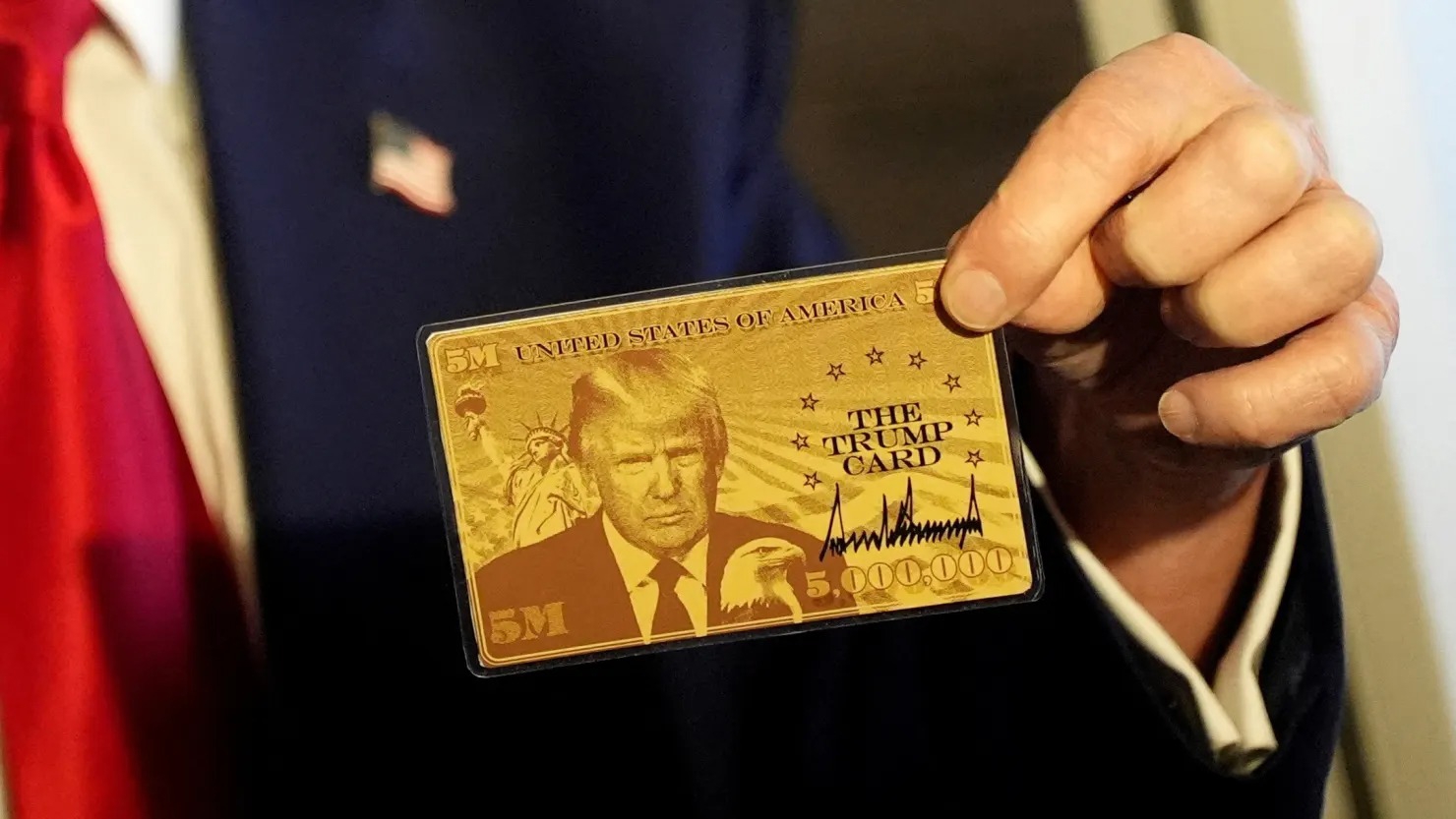 Tổng thống Mỹ Donald Trump cầm Thẻ Trump khi phát biểu với truyền thông trên máy bay đến Florida vào ngày 3/4/2025 - Ảnh: Reuters