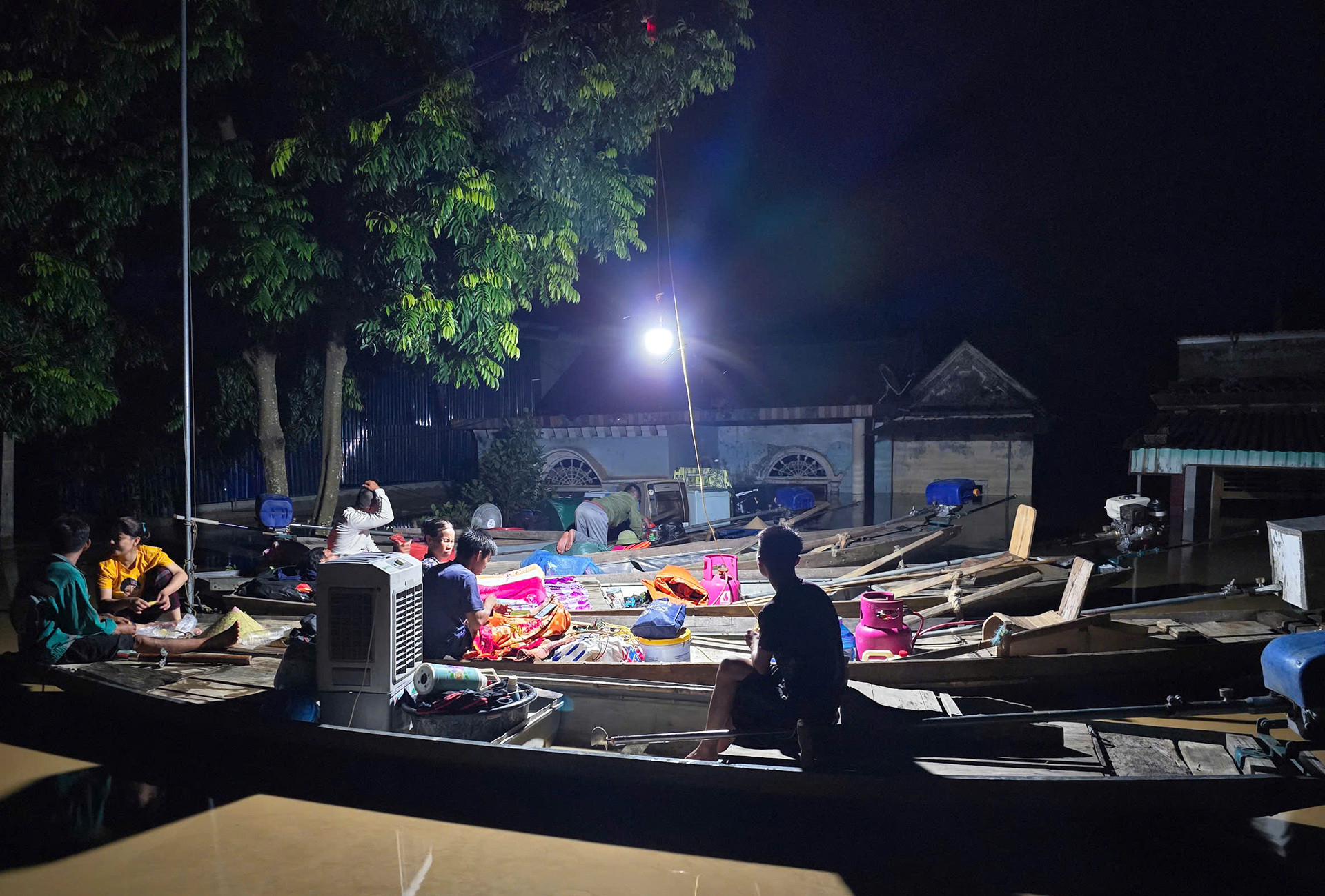 Người dân xóm vạn chài ở Con Cuông trắng đêm ngồi chờ nước rút. Ảnh: Phan Ngọc