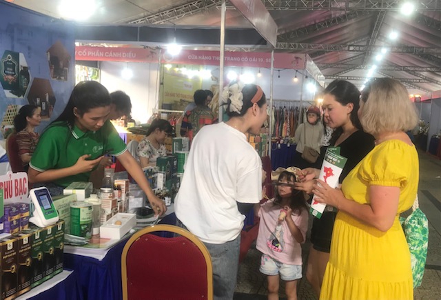 Kh&aacute;ch nước ngo&agrave;i mua sản phẩm OCOP tại điểm khai mạc Tuần lễ Thương mại số v&agrave; kết nối v&ugrave;ng Đ&agrave; Nẵng 2025. Ảnh Ng&ocirc; Anh Văn