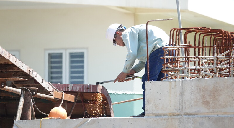 Công nhân thi công phần mặt cầu trong điều kiện thời tiết nắng nóng để kịp tiến độ.