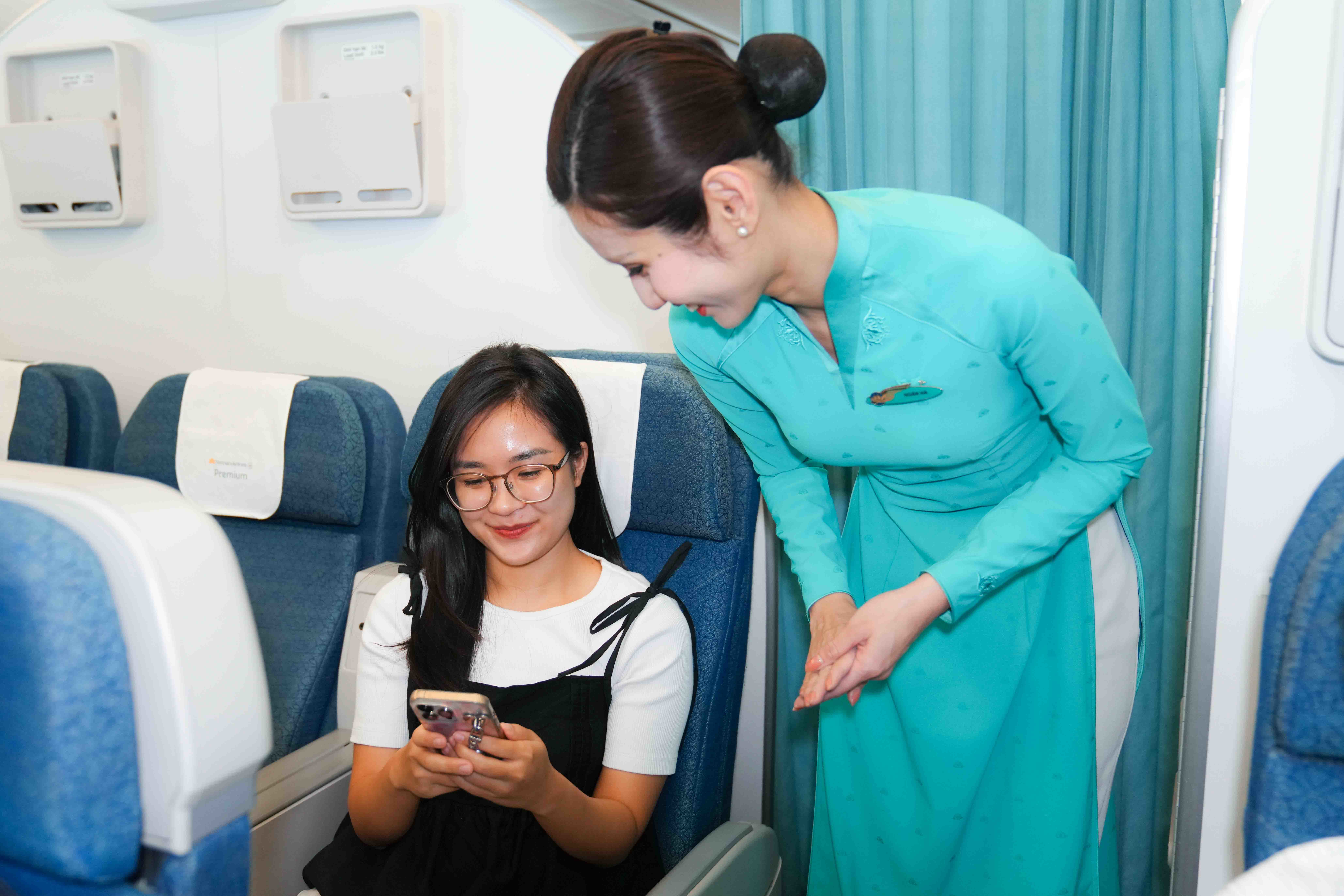 Tiếp viên hướng dẫn khách kết nối internet trên chuyến bay.
