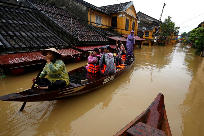 Du khách chèo thuyền đi giữa phố cổ Hội An. - Ảnh: Reuters