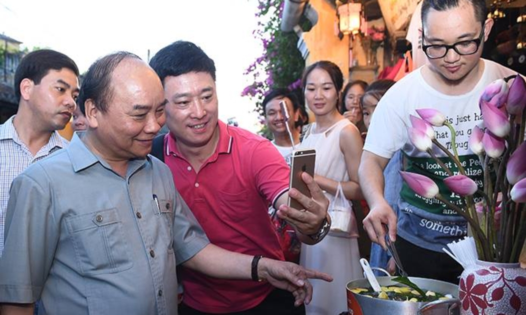 Thủ tướng Nguyễn Xuân Phúc chụp ảnh cùng du khách tại Hội An, chiều 8/8 - Ảnh: VGP.<br>