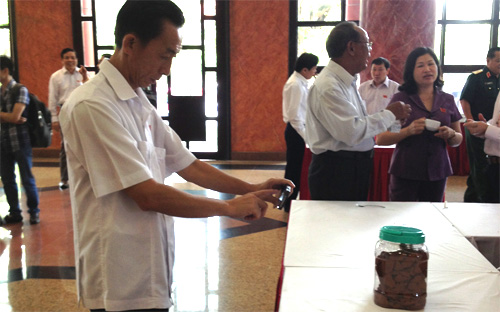 Đại biểu ghi lại hình ảnh mẫu bùn đỏ của dự án bauxite tại Tây Nguyên, được trưng bày tại hành lang Quốc hội - Ảnh: NH.<br>