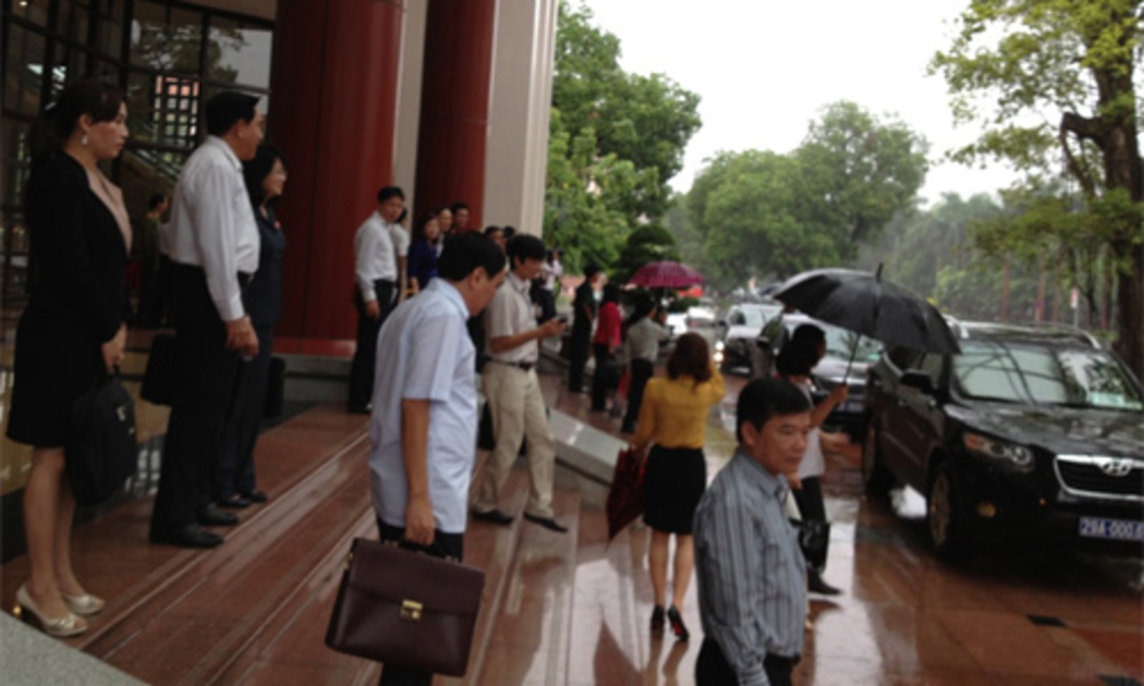 Các đại biểu Quốc hội lên xe trở về đoàn thảo luận lấy phiếu tín nhiệm trong trời mưa tầm tã, sáng 10/6 - Ảnh: NH.