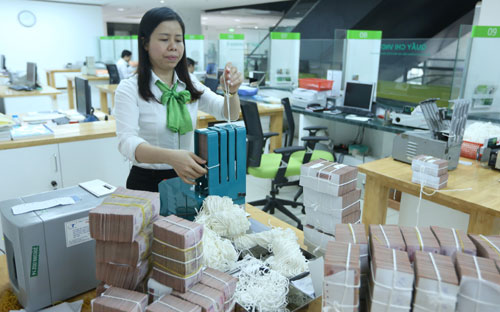 Trước mắt, nhu cầu vay vốn của Chính phủ bằng trái phiếu như trên tạm 
thời bớt chia sẻ nguồn vốn trên thị trường, cung vốn của các ngân hàng 
thương mại có thể tiếp tục dư thừa rõ hơn - Ảnh: Quang Phúc.<br>