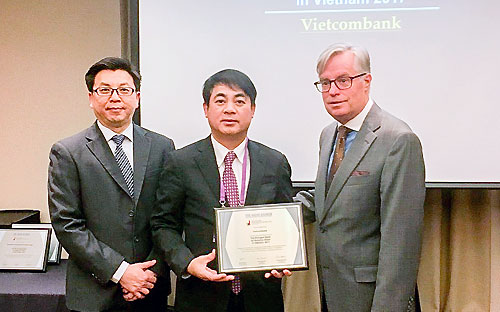 Ông Nghiêm Xuân Thành (giữa), Chủ tịch Hội đồng Quản trị Vietcombank nhận giải thưởng từ The Asian Banker.<br>
