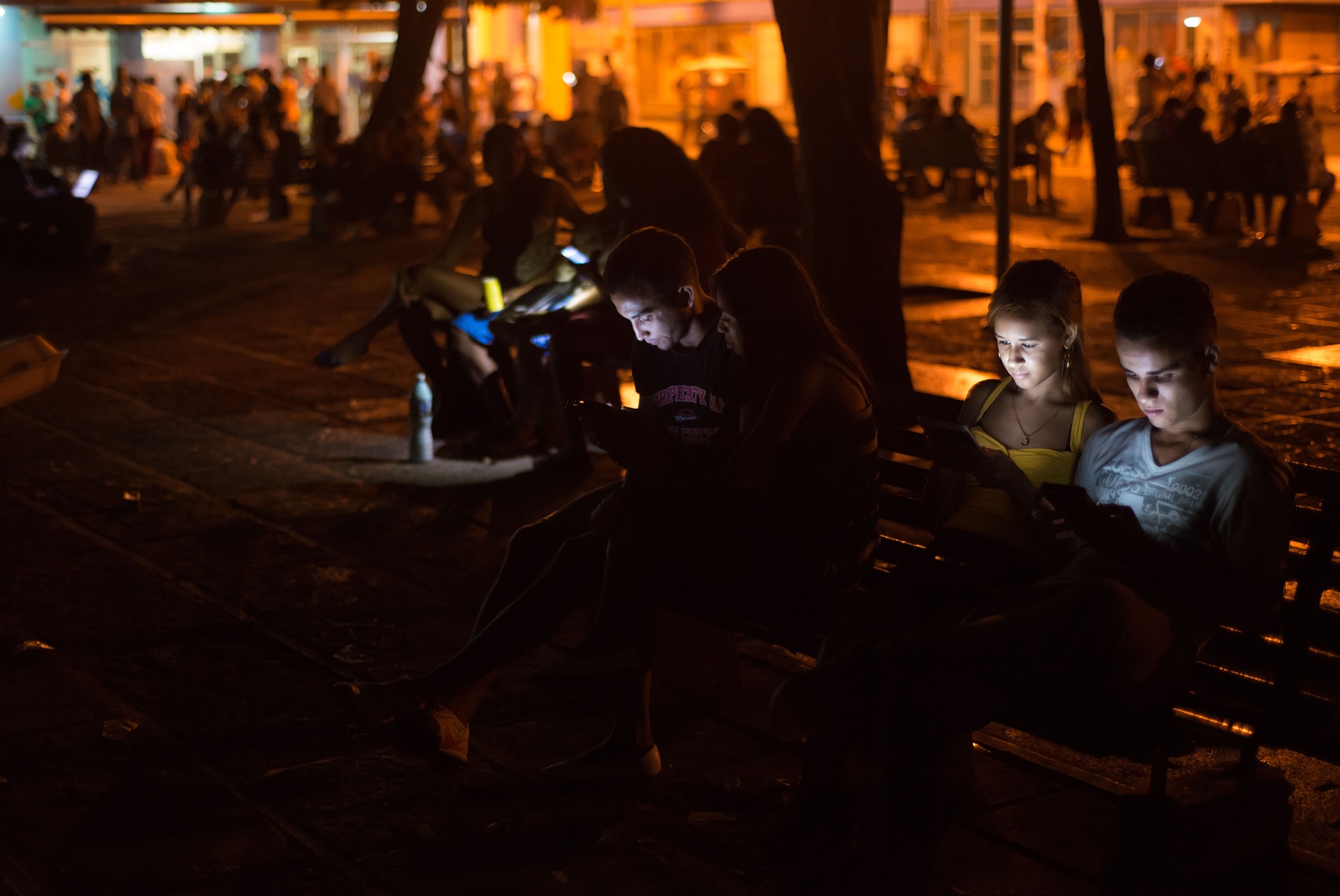 Thanh niên Cuba vào Internet bằng thiết bị di động, tại một điểm phát wi-fi công cộng.<br>