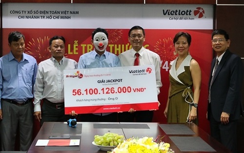 Một người trúng giải xổ số của Vietlott đeo mặt nạ nhận thưởng.