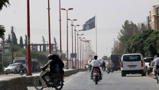 Cờ IS trên đường phố ở thị trấn Tel Abyad ở Syria, gần biên giới với Thổ Nhĩ Kỳ, tháng 9/2014 - Ảnh: Reuters.<br>