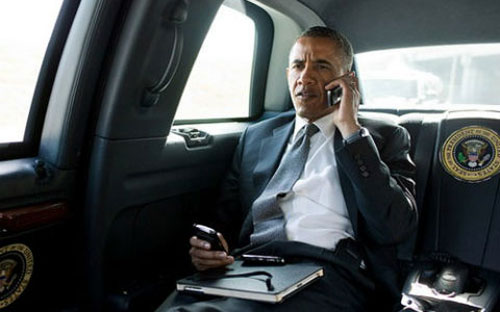 Không ít lần giới truyền thông bắt gặp Tổng thống Mỹ đang bận rộn với chiếc điện thoại BlackBerry cũ kỹ của ông - Ảnh: News.<br>
