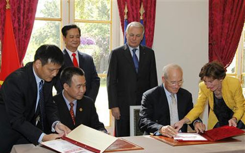 Thủ tướng Nguyễn Tấn Dũng (đứng, trái) và Thủ tướng Pháp Jean-Marc Ayrault (đứng, phải) chứng kiến lễ ký kết thỏa thuận giữa Giám đốc điều hành VietJet Air Lưu Đức Khánh (ngồi, thứ hai từ trái sang) và Giám đốc phụ trách hợp đồng và đàm phán của Airbus, ông Christophe Mourey (ngồi, thứ hai từ phải sang) tại Paris ngày 25/9/2013 - Ảnh: Reuters.<br>