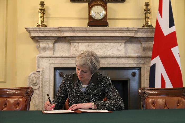 Thủ tướng Anh Theresa May ký lá thư gửi Chủ tịch Hội đồng EU Donald Tusk để kích hoạt Điều 50 Hiệp ước Lisbon, nhằm khởi động tiến trình đưa Anh ra khỏi EU, ngày 28/3 tại Văn phòng Nội các Anh ở London - Ảnh: Reuters.<br>