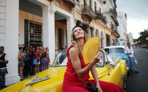 Siêu mẫu Gisele Bundchen tạo dáng bên một chiếc xe cổ trước buổi trình diễn của Chanel ở Havana - Ảnh: Reuters/BBC.<br>