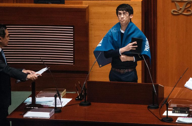 Nghị sỹ Sixtus "Baggio" Leung của Hồng Kông mang một tấm băng rôn ghi dòng chữ "Hồng Kông không phải là Trung Quốc" khi tuyên thệ hôm 12/10 - Ảnh: Bloomberg.<br>