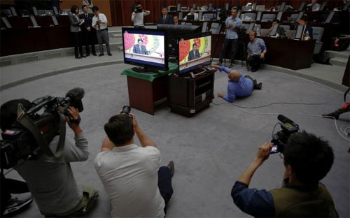 Các nhà báo quốc tế tác nghiệp quanh màn hình phát trực tiếp bài phát biểu của nhà lãnh đạo Triều Tiên Kim Jong Un tại Đại hội Đảng Lao động nước này ngày 8/5 - Ảnh: Reuters.<br>