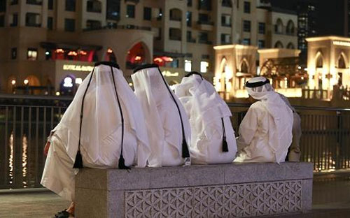 Những người đàn ông địa phương trong trang phục truyền thông ngồi bên ngoài trung tâm thương mại Dubai Mall ở Dubai, Các tiểu vương quốc Arab thống nhất (UAE) - Ảnh: CNBC/Bloomberg.<br>