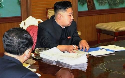 Nhà lãnh đạo Triều Tiên Kim Jong Un tại một cuộc họp hồi đầu năm. Bên cạnh ông là một chiếc smartphone màu đen.
