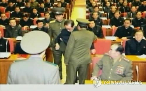 Hình ảnh vụ bắt giữ ông Jang ngay trong cuộc họp trên truyền hình nhà nước Triều Tiên - Ảnh: Yonhap.<br>