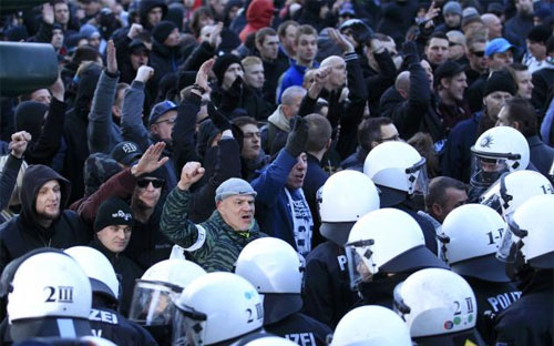 Người biểu tình phản đối người di cư ở Cologne, Đức ngày 9/1 đối mặt hàng rào cảnh sát chống bạo động - Ảnh: Reuters.<br>