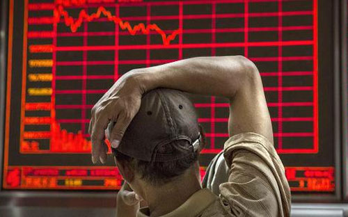 Một nhà đầu tư chứng khoán Trung Quốc đang theo dõi diễn biến giá cổ phiếu trên bảng điện tử một công ty môi giới ở Bắc Kinh - Ảnh: Getty.<br>