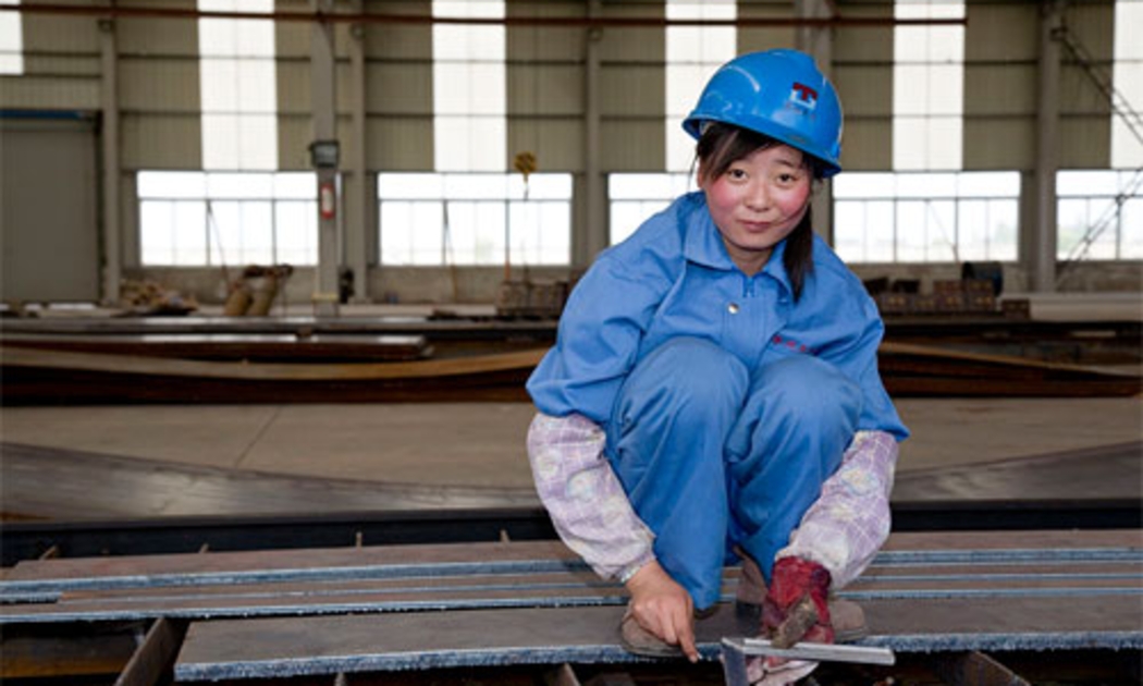 Một nữ công nhân làm việc trong một nhà máy thép của Trung Quốc.<br>