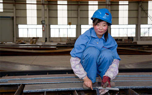 Một nữ công nhân làm việc trong một nhà máy thép của Trung Quốc.<br>