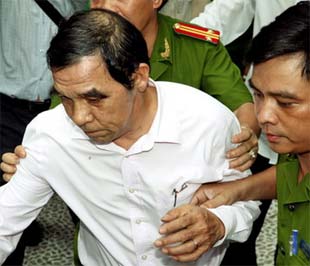 Công an dẫn giải ông Sĩ ra khỏi nhà riêng tại Tp.HCM - Ảnh: TTXVN.