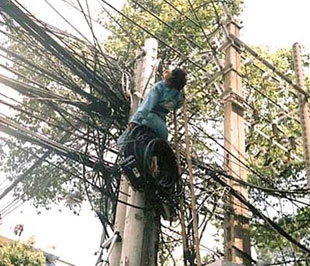 Công nhân của Công ty Viettel bị điện giật trên "mạng nhện" bằng dây điện tại quận 1, Tp.HCM - Ảnh: LĐ.