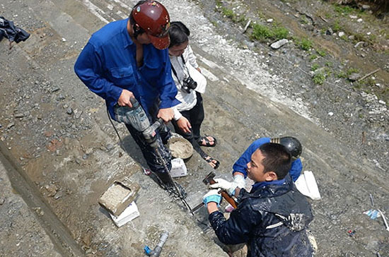 Công nhân xử lý sự cố rò rỉ nước đập thủy điện Sông Tranh 2 - Ảnh: NLĐ.