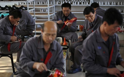 Công nhân người Triều Tiên đang làm việc trong một nhà máy sản xuất giày ở Dandong, Trung Quốc vào tháng 10/2012 - Ảnh: Reuters.<br>