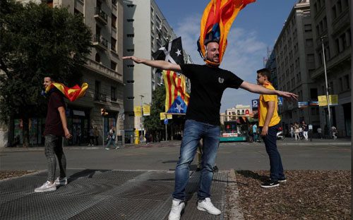 Người dân mang cờ ly khai của Catalonia trên đường phố Barcelona hôm 3/10 - Ảnh: Reuters.<br>
