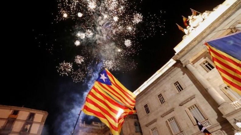 Người ủng hộ Catalonia độc lập treo cờ Catalonia và bắn pháo hoa trước tòa nhà nghị viện vùng này ngày 27/10 - Ảnh: Reuters.