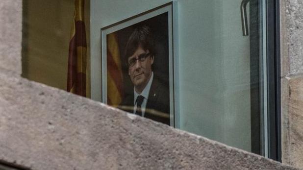 Ông Carles Puigdemont, nhà lãnh đạo bị sa thải của Catalonia, đã sang Bỉ, nhưng ảnh của ông vẫn được treo tại tòa nhà chính quyền xứ này hôm 30/10 - Ảnh: Getty/BBC.