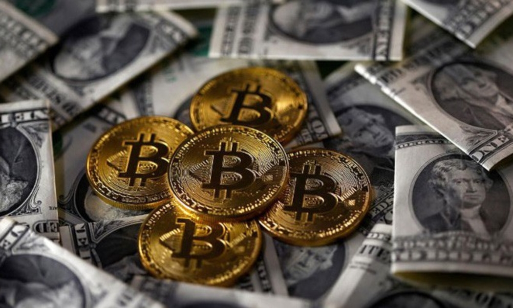 Những đồng tiền ảo Bitcoin mô hình đặt cạnh những đồng tiền giấy trong một bức hình minh họa - Ảnh: Reuters.