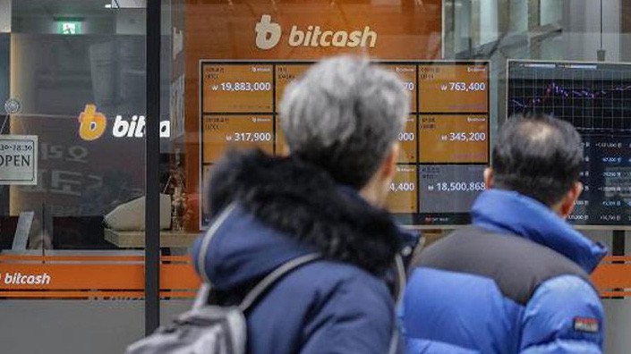 Hai người đàn ông đi qua bảng giá tiền ảo bên ngoài một sàn giao dịch tiền ảo ở Seoul, Hàn Quốc - Ảnh: Getty/CNBC.