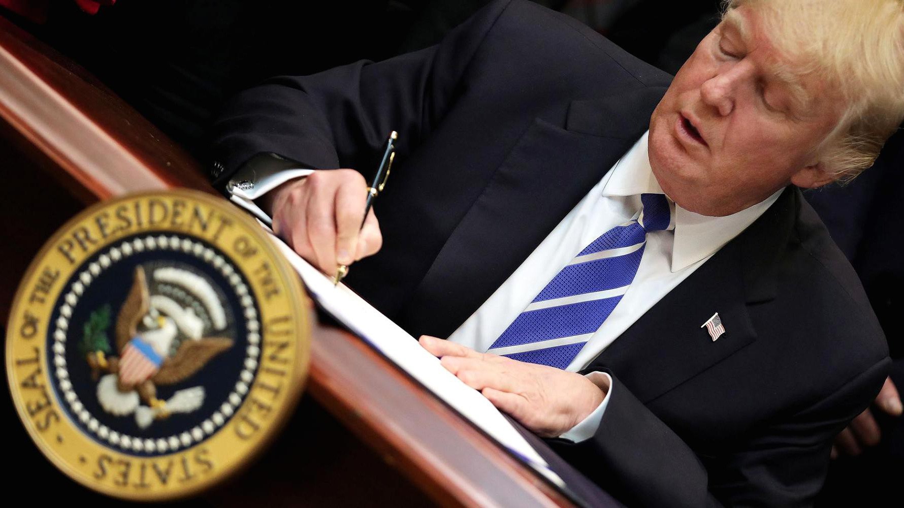 Tổng thống Mỹ Donald Trump đặt bút ký một sắc lệnh hồi tháng 3/2017 - Ảnh: Reuters/CNBC.