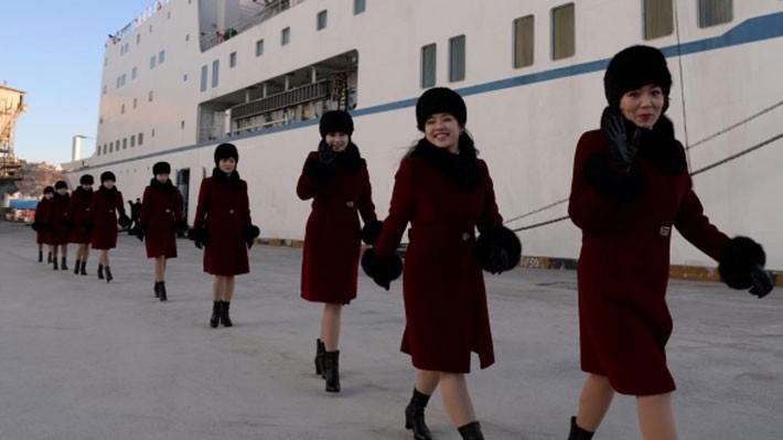 Các nữ nghệ sỹ thuộc đoàn văn công Triều Tiên bước xuống từ chuyến phà đi qua biên giới hai miền ngày 6/2 - Ảnh: Reuters.