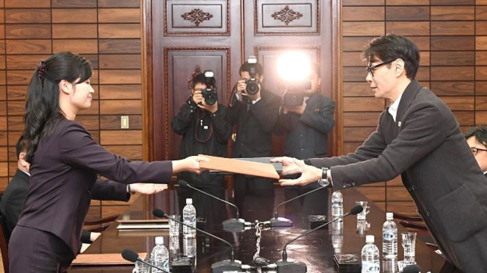 Đại diện Triều Tiên (trái) và đại diện Hàn Quốc trao đổi tài liệu tại cuộc đàm phán ở Panmumjom ngày 20/3 - Ảnh: Reuters.