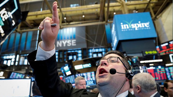 Một nhà giao dịch cổ phiếu đang đặt lệnh trên sàn NYSE ở New York ngày 3/5 - Ảnh: Reuters.