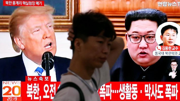 Người đàn ông đi qua một màn hình phát sóng bản tin về việc Triều Tiên phá dỡ khu thử hạt nhân Punggye-ri, trên đường phố Seoul ngày 24/5 - Ảnh: Reuters.