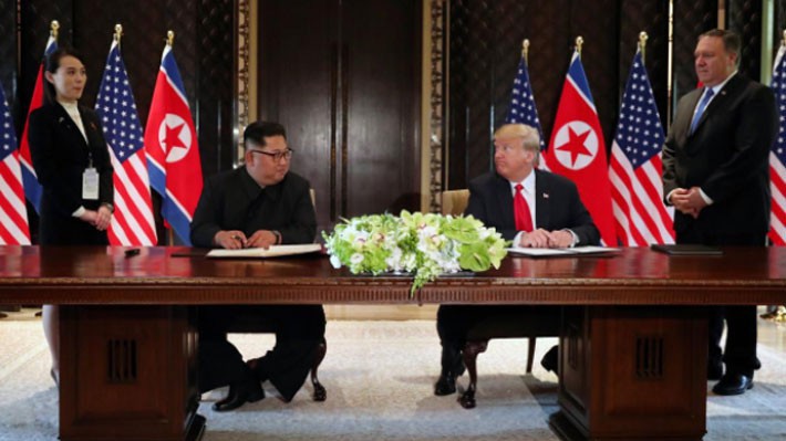Nhà lãnh đạo Triều Tiên Kim Jong Un (trái) và Tổng thống Mỹ Donald Trump nhìn nhau trước khi đặt bút ký thỏa thuận tại Singapore ngày 12/6 - Ảnh: Reuters.