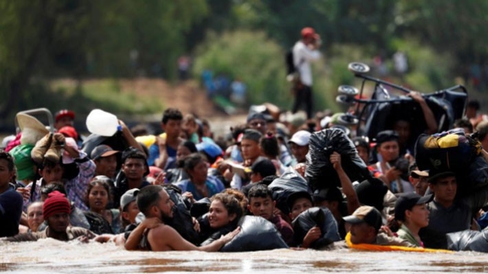 Người di cư vượt sông để đi qua biên giới giữa Guatemala và Mexico trên hành trình tiến về biên giới Mỹ, ngày 29/10 - Ảnh: Reuters.