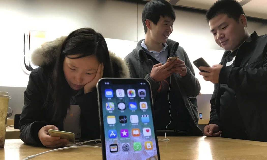 Khách hàng xem điện thoại iPhone trong một cửa hiệu Apple Store ở Bắc Kinh, Trung Quốc - Ảnh: AP.