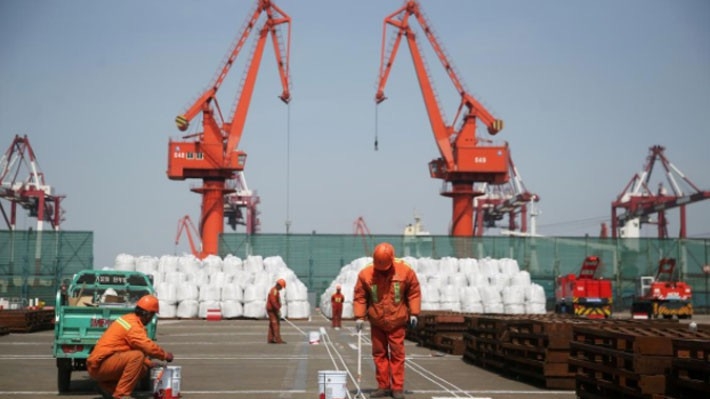 Các công nhân làm việc ở một bến cảng ở Thanh Đảo, Trung Quốc - Ảnh: Reuters.